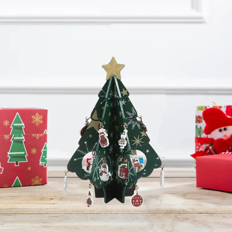 Small green Christmas tree with a gold star on top, surrounded by red and green gift boxes.
